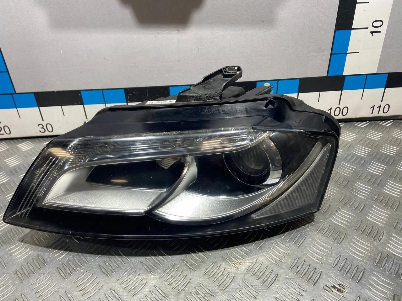 [Б/У] Фара левая правый руль Audi A3 8P1 - Отремонтировано крепление, незначительная царапина [ХОРОШЕЕ] [Код: 00666281 ]