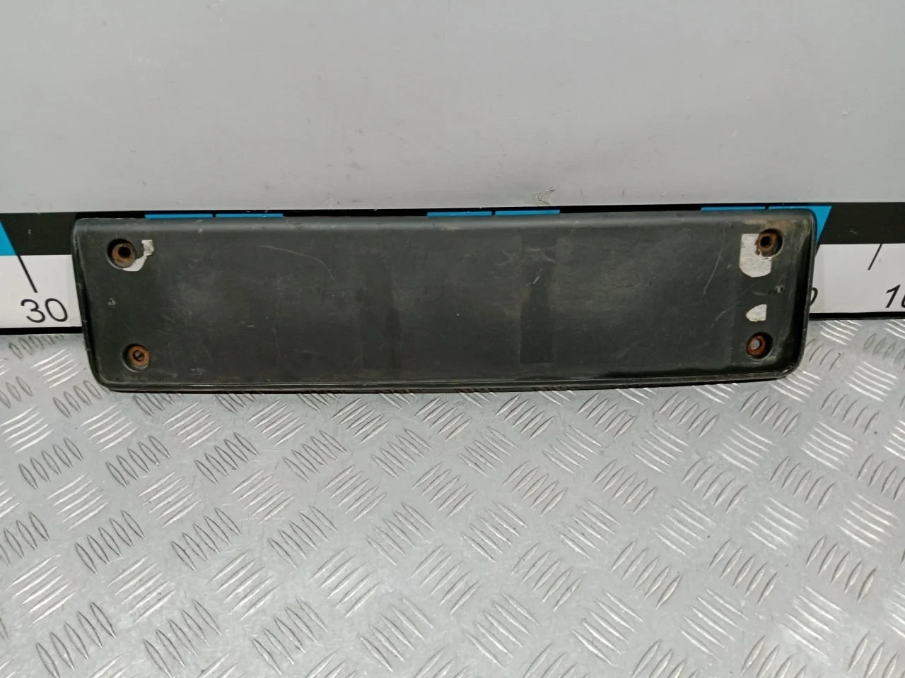 [Б/У] Накладка переднего бампера под гос номер - Отверстия от шурупов [ХОРОШЕЕ] [Код: 00659914 ]